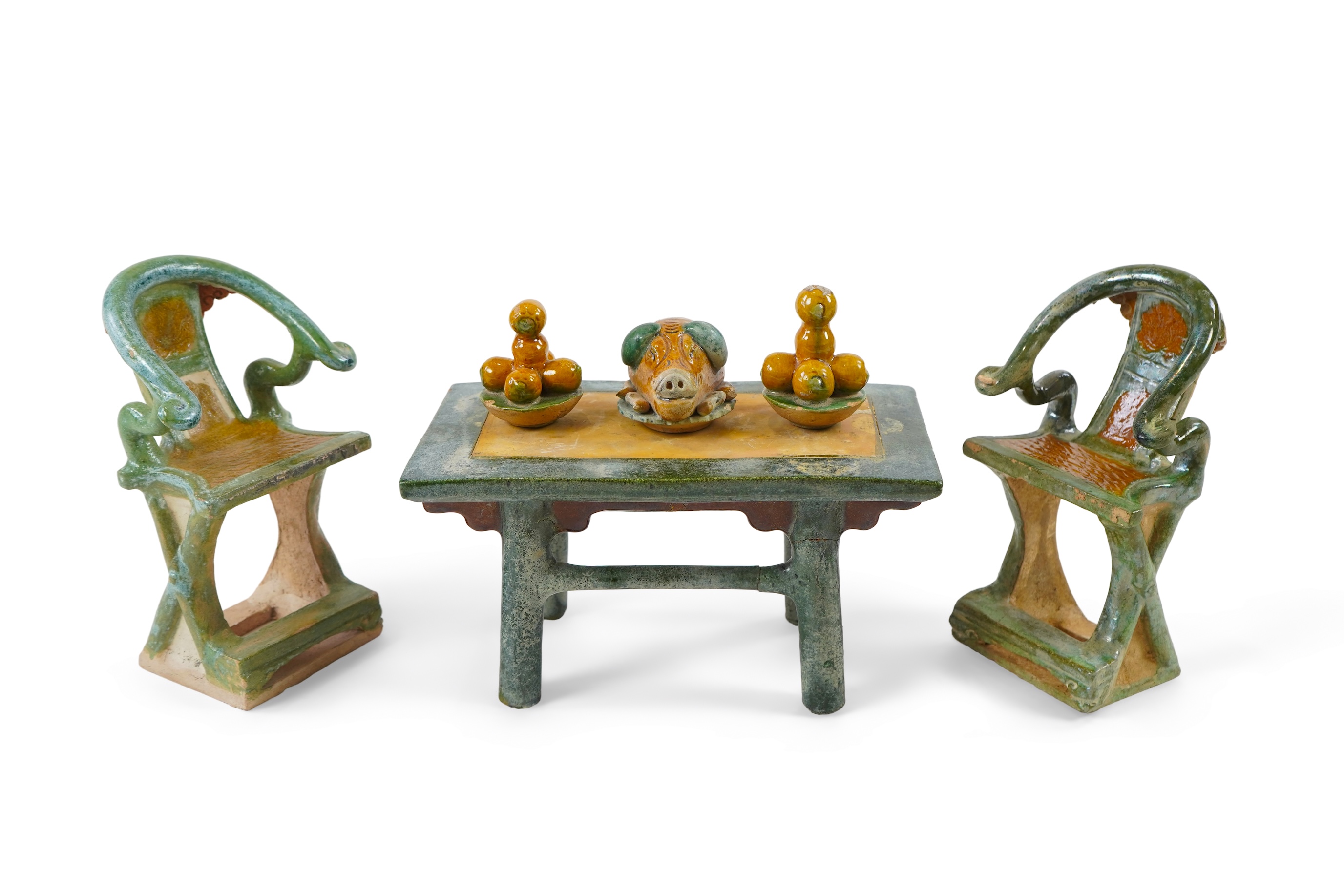 A set of Chinese Ming Sancai models of table with offerings and a pair of horseshoe shaped armchairs, 16th century